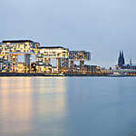 Cologne Cathedral and Rheinau Harbor at night.