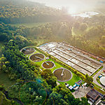 Aerial shot of a sewage treatment plant placed near a river, in Denmark.