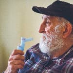 Elderly man using an inhalation mask.